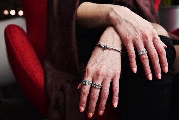 Woman wearing minimalist stackable ring sets on three fingers